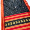 Black saree with golden zari work and red borders.
