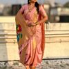 A woman wearing a pink Nauvari saree with floral design.