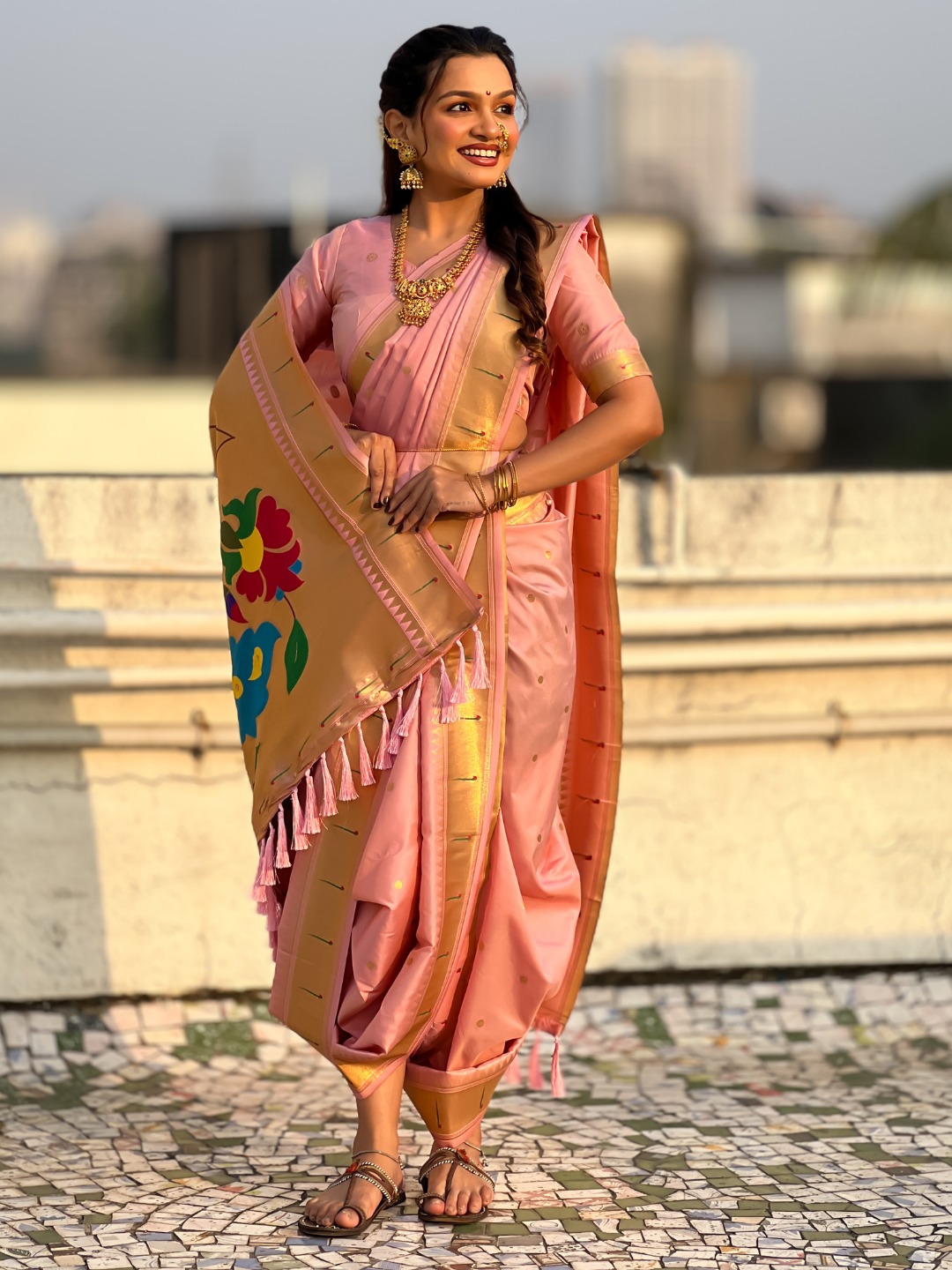 A woman wearing a pink Nauvari saree with floral design.