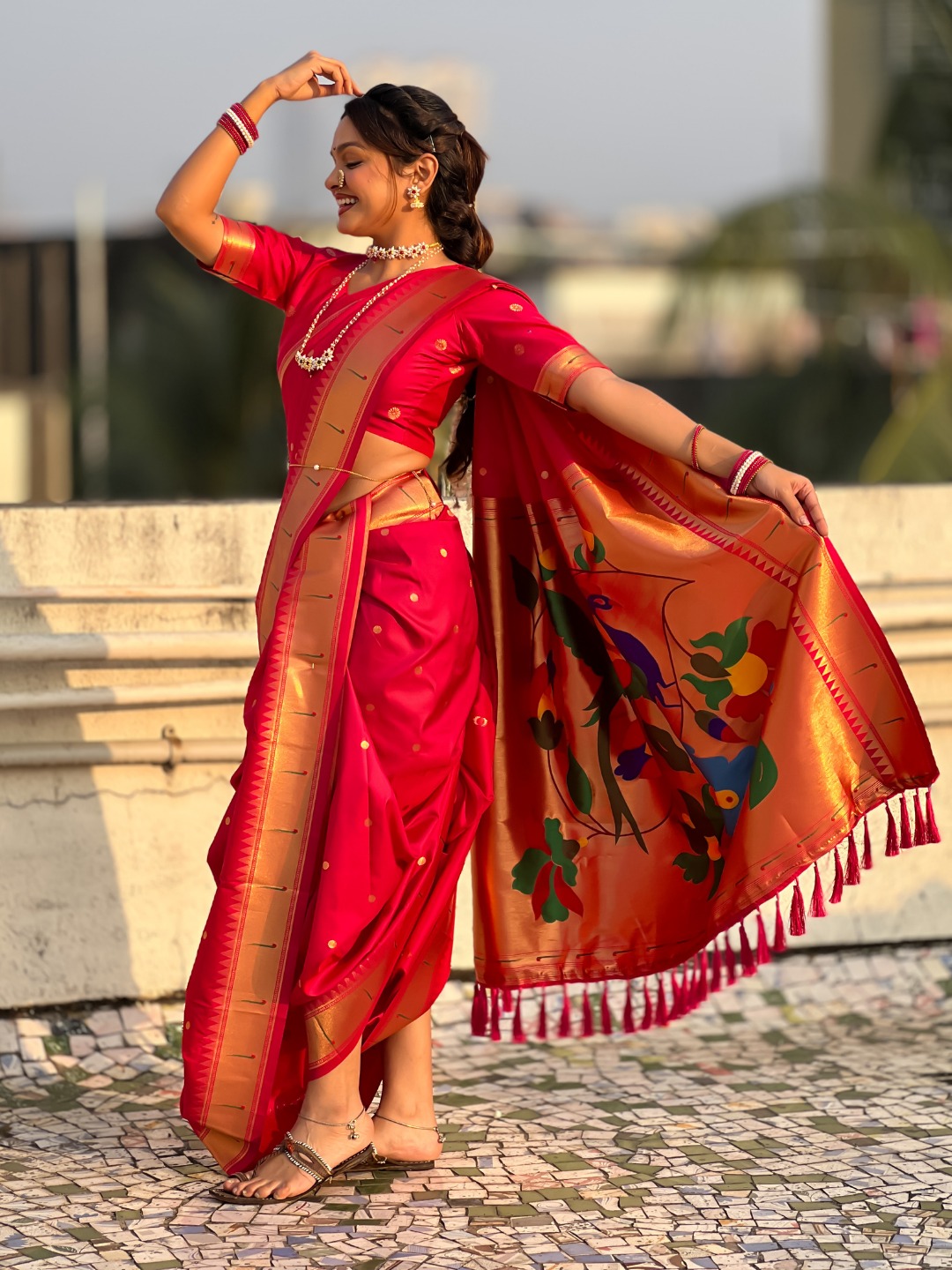 A vibrant red Nauvari saree with floral patterns.