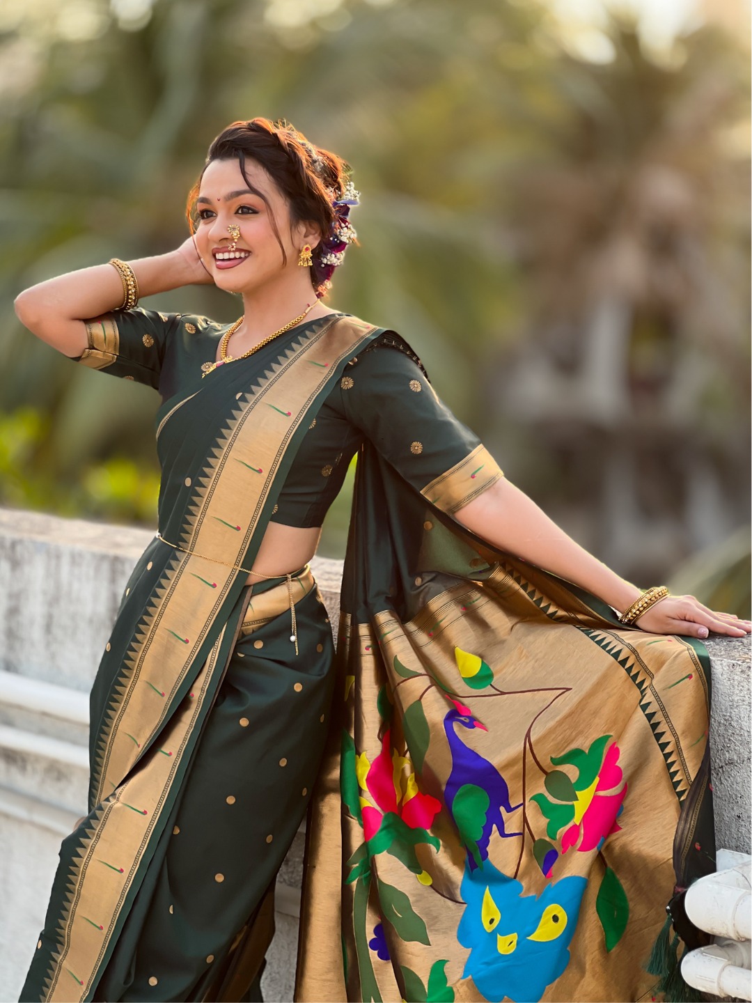 A woman wearing a green Nauvari saree with floral designs.