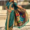 A woman elegantly draped in a teal Nauvari saree with floral designs.