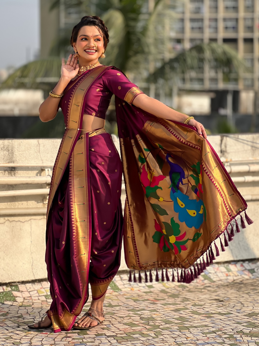 A model showcasing a Nauvari Saree in purple with floral designs.