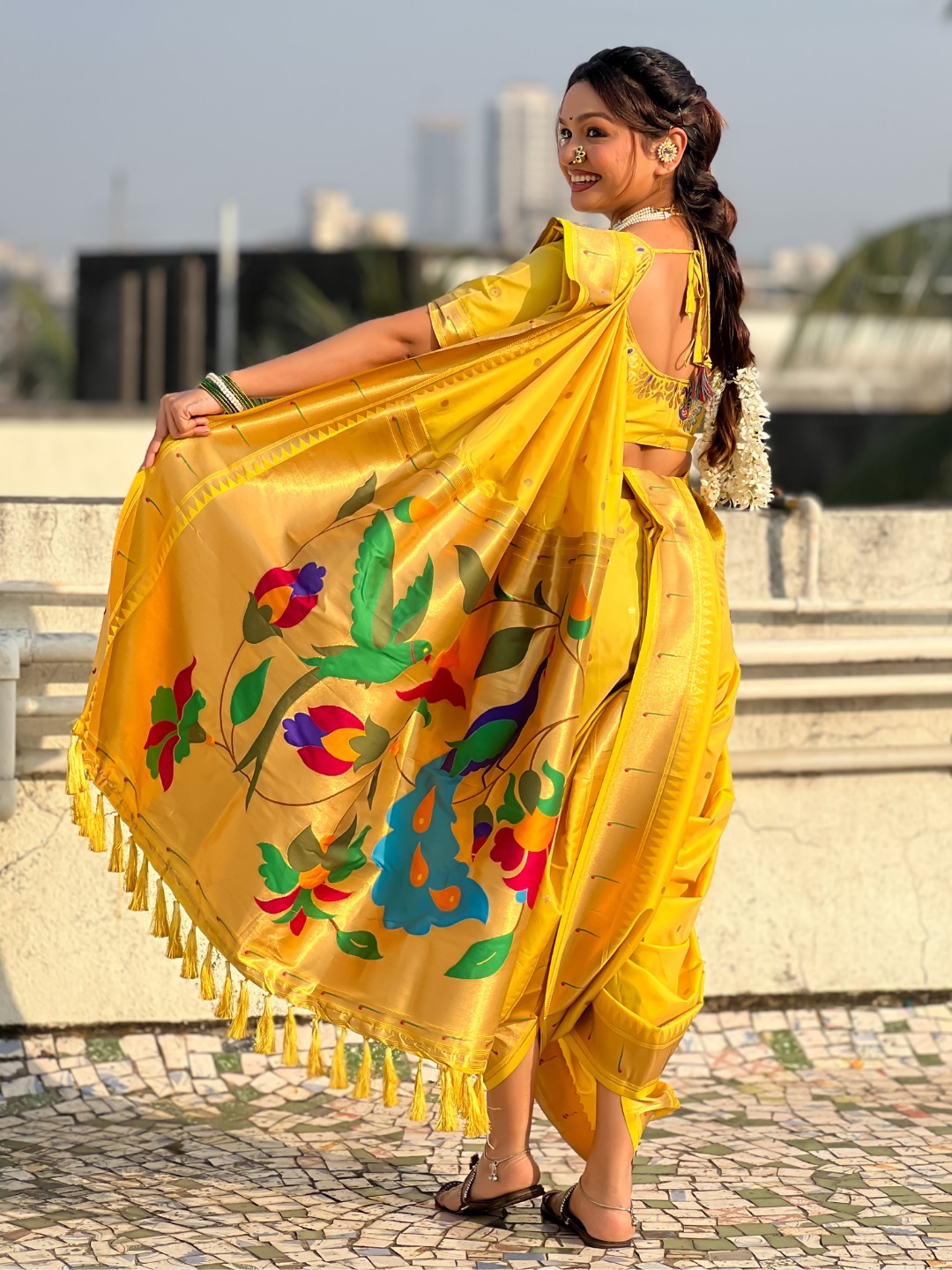 A vibrant yellow Nauvari saree with floral designs.