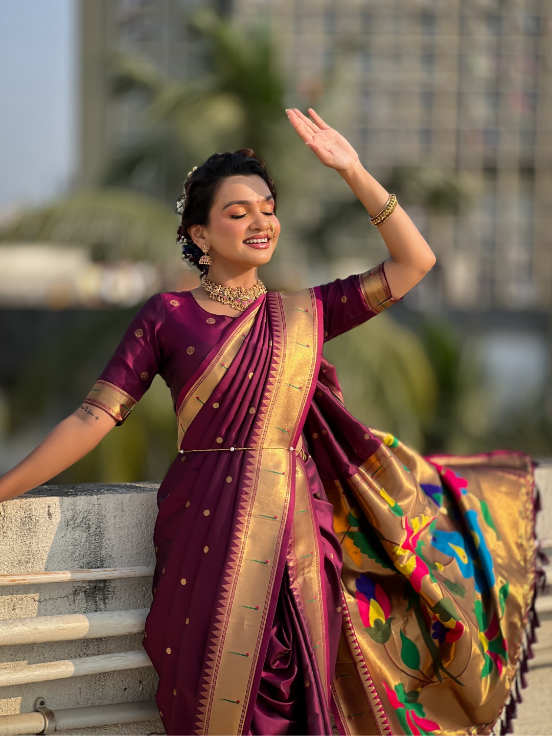 A woman wearing a purple Nauvari saree with floral designs.