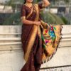 A woman wearing a brown Nauvari saree with golden accents.
