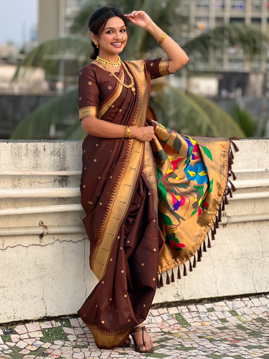 A woman wearing a brown Nauvari saree with golden accents.